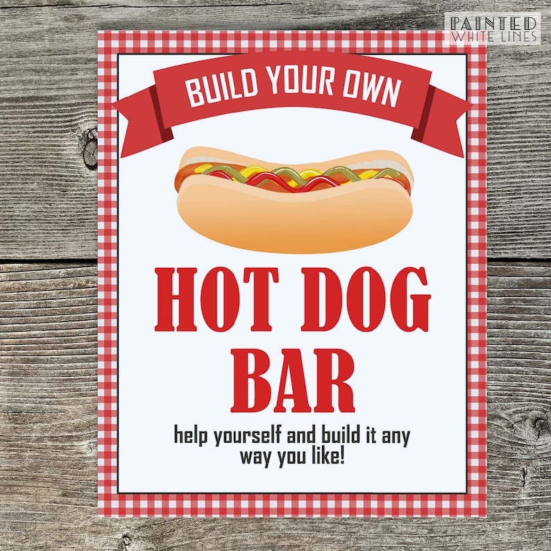 May include: A white sign with red and white checkered border, a red banner with the text "BUILD YOUR OWN" and a cartoon hot dog. The text "HOT DOG BAR" is in red letters. The sign says "help yourself and build it any way you like!"