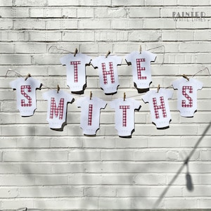 May include: A banner with the words "THE SMITHS" spelled out in white letters on red and white gingham fabric. The letters are attached to a string with clothespins.
