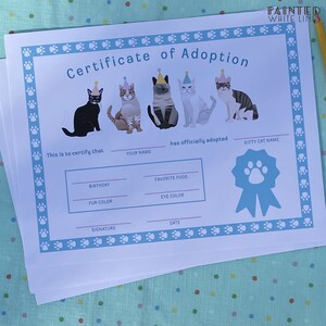 Puede incluir: Certificado de adopci&oacute;n imprimible para un gato. El certificado tiene un borde azul con huellas de patas y una cinta azul con una huella de pata. Tiene espacios para rellenar el nombre del gato, su cumplea&ntilde;os, su comida favorita, el color de su pelaje, el color de sus ojos, y el nombre, la firma y la fecha del adoptante.