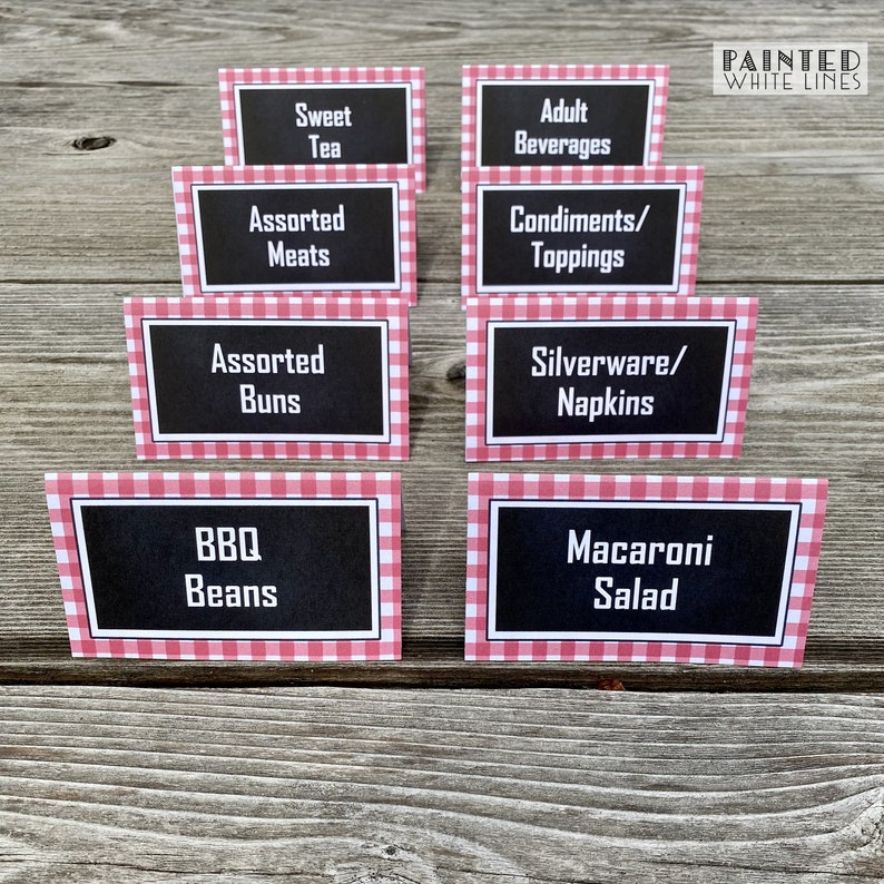 May include: Eight red and white gingham table cards with black text. The cards list various food and beverage options for a party or event. The text on the cards reads: Sweet Tea, Assorted Meats, Assorted Buns, BBQ Beans, Adult Beverages, Condiments/Toppings, Silverware/Napkins, Macaroni Salad.