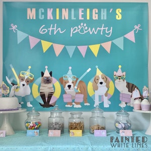 May include: A turquoise blue banner with a pink, yellow, and white bunting across the top. The banner says "McKinleigh's 6th pawty". There are six cartoon animals on the banner, including a cat, a bulldog, and a beagle. The animals are wearing party hats and sunglasses. Below the banner is a table with six glass jars filled with candy, cookies, and other treats. The table is covered in a light blue tablecloth with white polka dots.