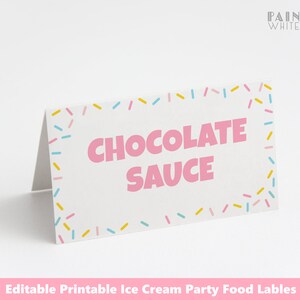 May include: Printable food label with a pink and white background. The label has a pink border with colorful sprinkles. The text "CHOCOLATE SAUCE" is in pink letters.