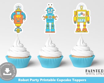 May include: Three robot cupcake toppers, one blue, one yellow, and one orange, with white frosting cupcakes in blue liners. The toppers are printable and perfect for a robot themed party.