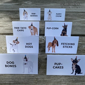 May include: A set of ten white cards with illustrations of dogs wearing party hats and text describing different dog-themed treats. The text includes "Paw-Tato Chips", "Pup-Corn", "Hot Dogs", "Fetching Sticks", "Dog Bones", "Pup-Cakes", "Paw-Berries", "Puppy Chow".