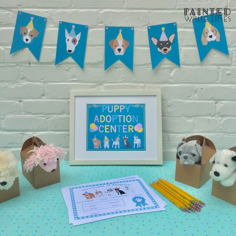 May include: A table setting for a puppy adoption event. There are brown boxes with stuffed puppies inside, a certificate of adoption, and a sign that says "Puppy Adoption Centre".