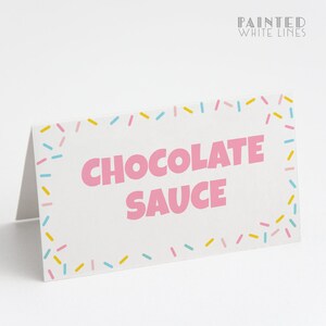 Pode incluir: Cart&atilde;o branco com uma borda rosa e confeitos coloridos ao redor da borda. O texto "CHOCOLATE SAUCE" est&aacute; escrito em letras rosa.