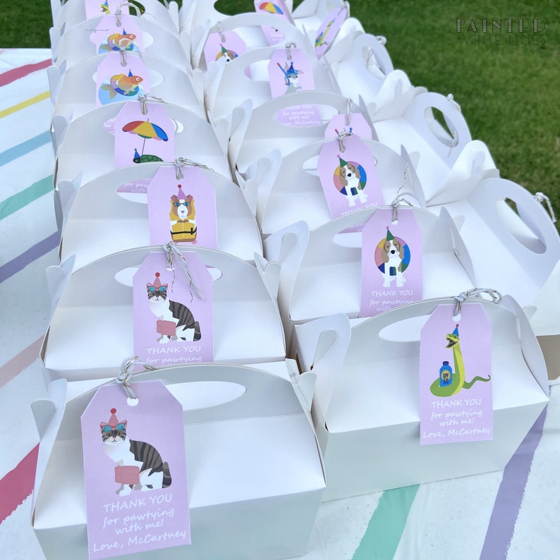 May include: White favor boxes with pink and purple tags featuring cartoon animals and the text "Thank you for pawtying with me! Love, McCartney".