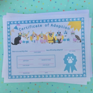 May include: A printable certificate of adoption for a pet. The certificate has a blue border with paw prints and a yellow sun. There are illustrations of cats and dogs wearing party hats and sunglasses. The text reads "Certificate of Adoption".