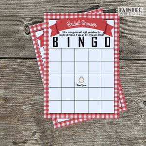 May include: A red and white gingham bridal shower bingo card with the text "Bridal Shower" and "BINGO" in black. The card has a free space with a gold ring icon. The text "Fill in each square with a gift you believe the couple will receive. If you get 5 in a row, yell BINGO!" is printed below the title.