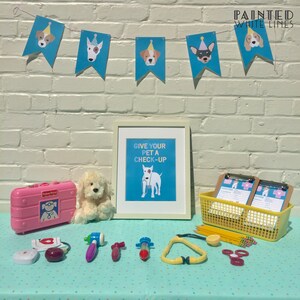 Op de afbeelding: Een kinderspeelset om te spelen als dierenarts. De set bevat een roze speelgoeddokterstas, een stethoscoop, een spuit, een thermometer, een speelgoedhond en een bord met de tekst "Geef je huisdier een check-up".