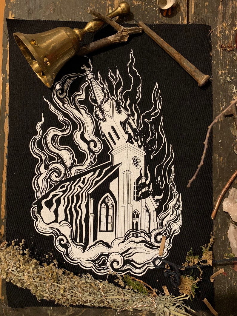 May include: Black and white patch with a church building engulfed in flames. The church has a steeple and a clock tower. The flames are stylized and look like smoke. The word "EVIL" is written in a stylized font in the smoke.