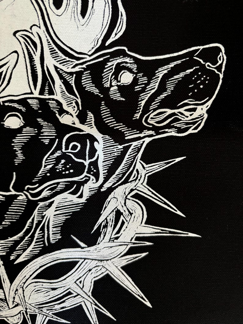 May include: Black and white illustration of a dog's head with a crown of thorns. The dog's head is facing to the right and the crown of thorns is around its neck. The image is in a stylized, graphic style.