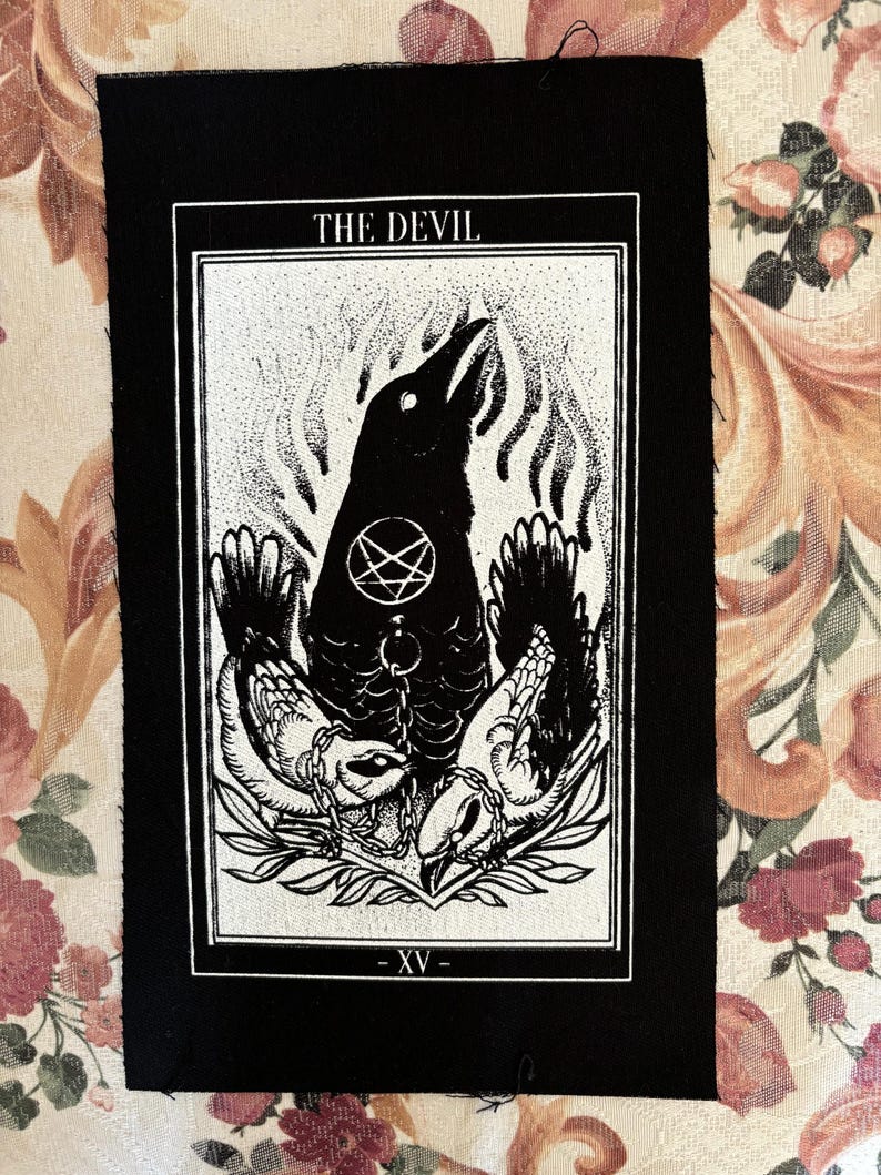 May include: Black and white tarot card patch featuring the Devil card image. The card depicts a crow with a pentagram on its chest, surrounded by two chained figures. The card number XV is at the bottom.