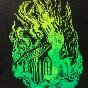 May include: A green and black illustration of a church engulfed in flames. The church is detailed with windows and a steeple. The flames are stylised and abstract.