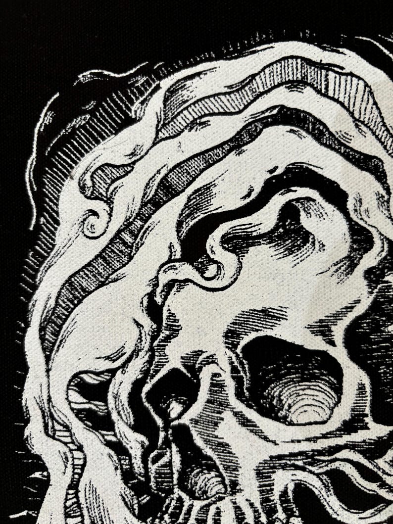 Op de afbeelding: Zwart-witte illustratie van een schedel met een draaiend ontwerp eromheen.