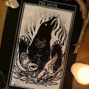 May include: Black and white illustration of a tarot card depicting The Devil. The card features a crow with a pentagram on its chest, chained to two smaller birds. The card is labeled "THE DEVIL" and "XV" at the top and bottom, respectively.