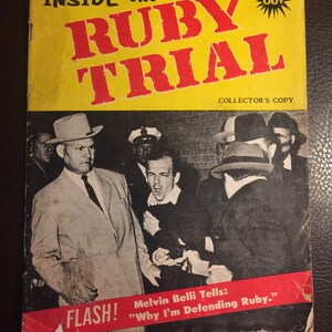May include: A vintage magazine cover with a yellow background and red text that reads "INSIDE the RUBY TRIAL" with a 60 cent price tag. The cover features a black and white photo of a man in a suit being escorted by police officers. The caption reads "FLASH! Melvin Belli Tells: "Why I'm Defending Ruby."
