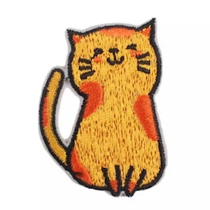 May include: Embroidered patch of a smiling cat in yellow and orange. The cat is sitting upright with its tail curved. The patch has a black outline and is designed for application on fabric items.