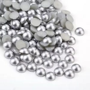 May include: A pile of silver pearl cabochons, also known as half pearls, for crafting and jewellery making.
