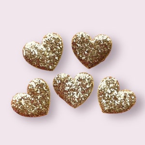 May include: Five gold glitter heart-shaped embellishments.