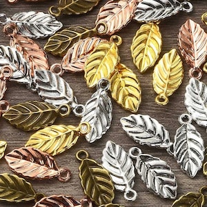 May include: Assortment of gold, silver, and copper leaf charms with a loop for attaching to jewelry or other crafts. The leaves are all the same shape but different sizes.