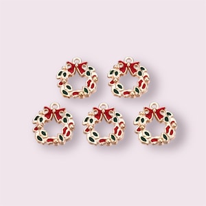 May include: Five gold-tone metal Christmas wreath charms featuring red bows and green holly leaves. The charms are ideal for adding a festive touch to jewellery, crafts, and other projects.