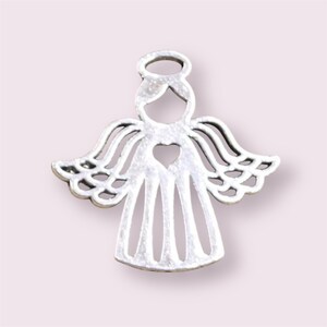 Puede incluir: Encanto de &aacute;ngel de plata con un coraz&oacute;n recortado y un halo. El &aacute;ngel tiene alas detalladas y un vestido sencillo.