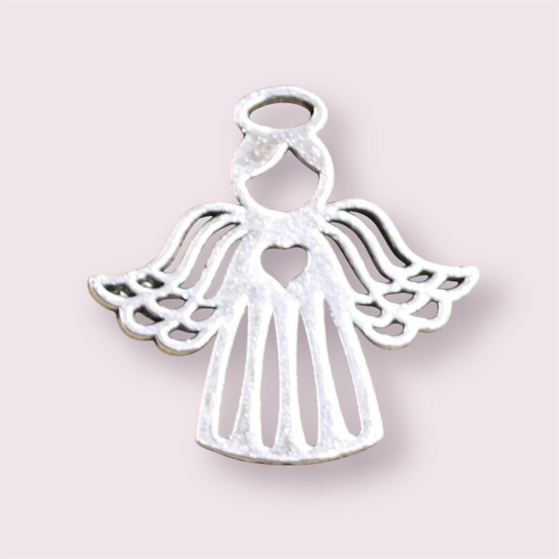 Puede incluir: Encanto de &aacute;ngel de plata con un coraz&oacute;n recortado y un halo. El &aacute;ngel tiene alas detalladas y un vestido sencillo.