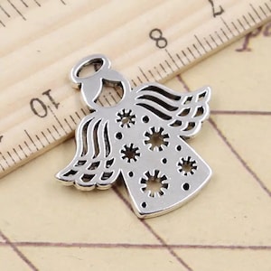 May include: Silver angel charm with a halo and intricate cut-out wings. The angel has a detailed design with small circles and a delicate pattern.