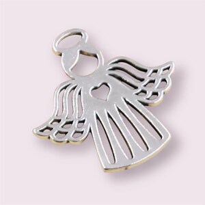 Puede incluir: Encanto de &aacute;ngel de plata con un coraz&oacute;n recortado. El &aacute;ngel tiene alas y un halo.