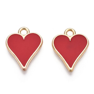 May include: Two gold-colored heart-shaped charms with red enamel. The charms have a small loop at the top for attaching to jewelry or other crafts.