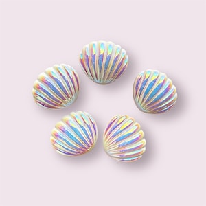 May include: Five iridescent white seashell-shaped buttons with a pearlescent finish.