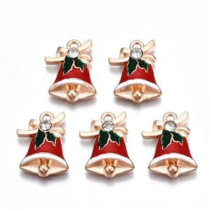 May include: Five gold-tone Christmas bell charms with red and green enamel and a clear rhinestone. Each charm has a loop for attaching to a necklace, bracelet, or other jewelry.
