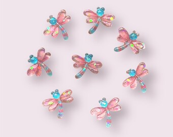 May include: Eight pink and blue dragonfly embellishments with glitter accents.
