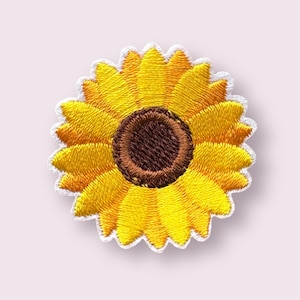 May include: Embroidered sunflower patch featuring a vibrant yellow petal design and a brown centre. The patch has a white border, likely for decorative use on clothing or bags.