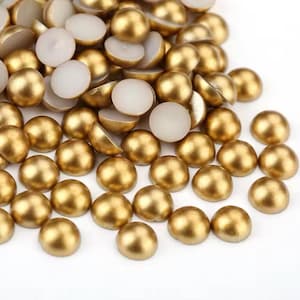 May include: A pile of gold-coloured round pearl-like beads. The beads are approximately 1.25 cm in diameter and have a smooth, shiny finish.
