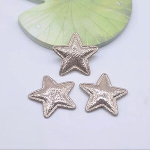 May include: Three silver glitter star-shaped fabric patches.