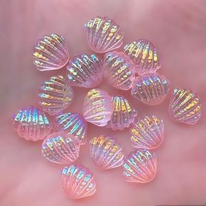 May include: A cluster of small, iridescent pink seashell-shaped beads. The beads have a textured surface and reflect a rainbow of colours. These decorative beads are ideal for crafting and jewellery making.