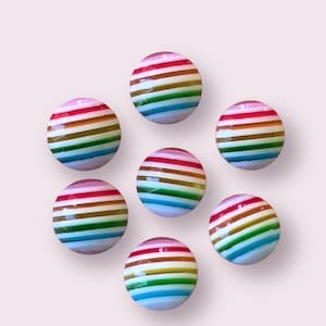 May include: Seven colorful striped glass balls with a rainbow pattern. The balls are round and have a glossy finish.