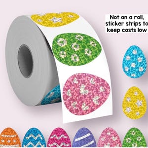 May include: A roll of Easter egg stickers with glitter designs in various colours, including yellow, green, pink, and blue. The text "Not on a roll, sticker strips to keep costs low" is visible. Additional loose stickers are scattered around.