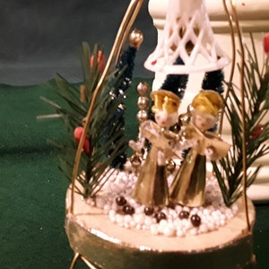 Christmas Caroler Vignette. Set in gold finish wire frame. 2 Gold foil, Spun Cotton Carolers, pipe cleaner trees, plastic bell, glass beads