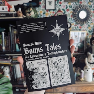 May include: A black booklet titled Haunted Maps Bonus Tales Old Lancashire & Nottinghamshire, featuring an alternative guide to folklore and haunted locations. The cover displays a compass rose and two detailed black and white illustrated maps.