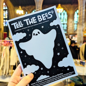 May include: A black and white magazine cover with a ghost illustration and the title "Tell the Bees: A catalogue of bizarre tales from Folklore, Fiction and History". The magazine is titled "Issue 3 Britain's Weirdest Ghost Stories" and lists ghost stories including "Hairy Hands of Dartmoor", "Haunted Starbucks", "England's Strangest Ghosts", "The Headless Phantom of Robin Hood's Bay", and "Gef the Talking Mongoose".
