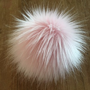 May include: A fluffy pink pom pom, ideal for adding a touch of whimsy to hats, scarves, or other accessories.