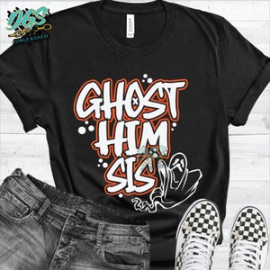 Puede incluir: Camiseta negra con la frase "GHOST HIM SIS" en letras blancas y naranjas. Una ilustración de fantasma blanco está a la derecha. La camiseta se combina con vaqueros y zapatillas a cuadros.