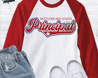 May include: A white and red baseball style t-shirt with the text "Westover High School Principal" in blue and red lettering with a red apple graphic.