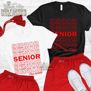 May include: Two white t-shirts with red text that reads "SENIOR" stacked on top of each other. The text is outlined in white. The bottom shirt has the text "Class of 2020" below the stacked "SENIOR" text. A black t-shirt with the same design is also shown. Red shorts are shown with the shirts.