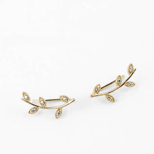May include: A pair of gold leaf ear climbers with small clear stones set in each leaf.