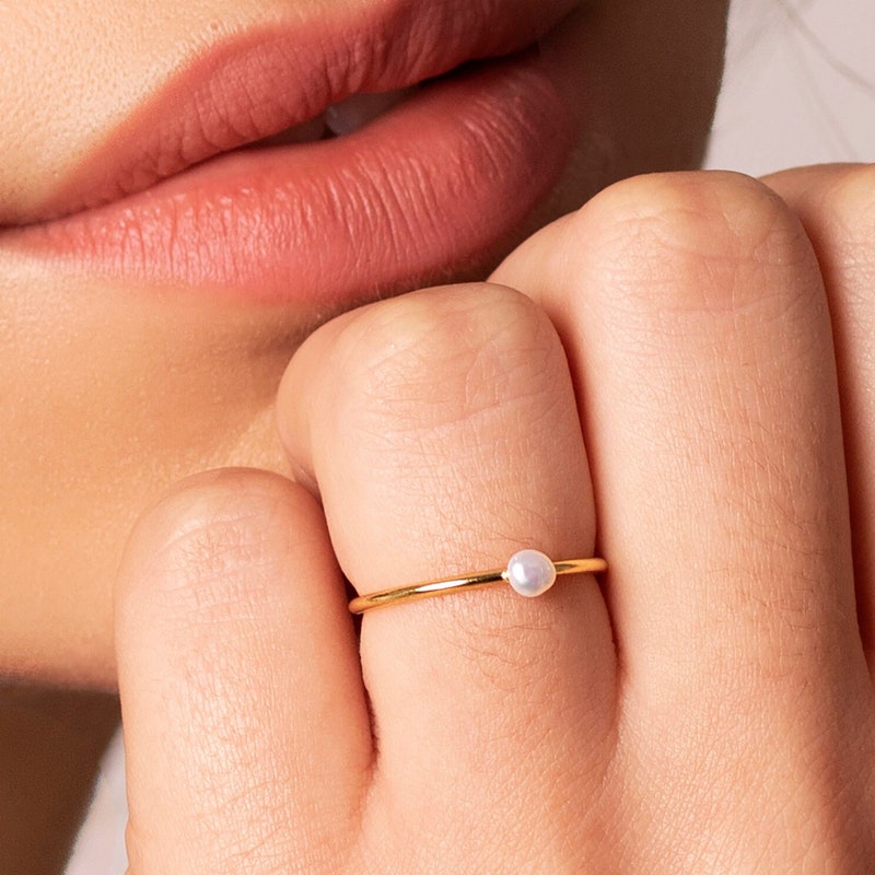 Delicate gold pearl ring photographed close up