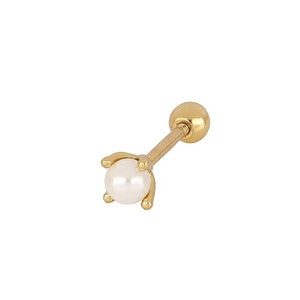 May include: A gold stud earring with a small white pearl